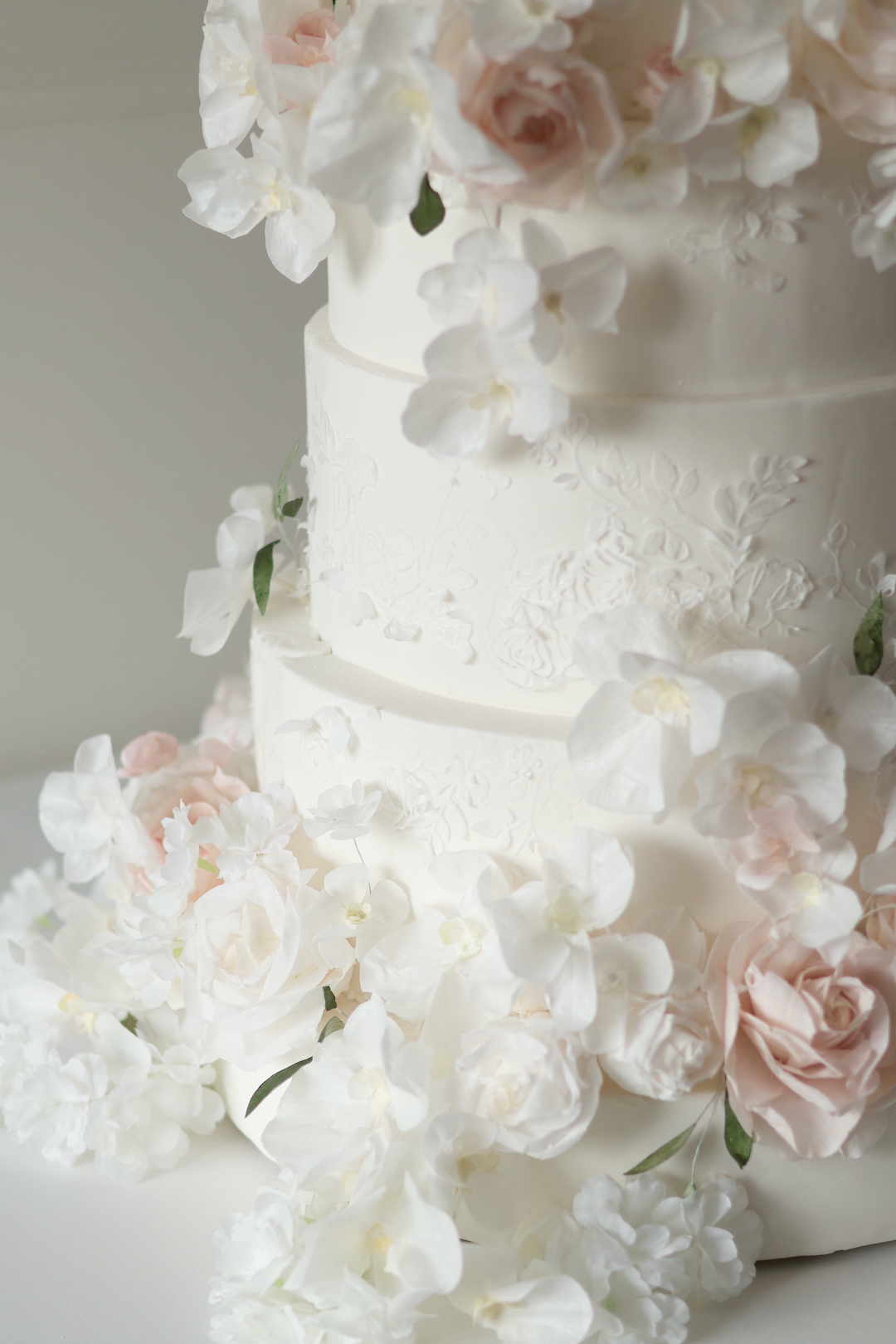 Floral wedding cake with lace appliqué