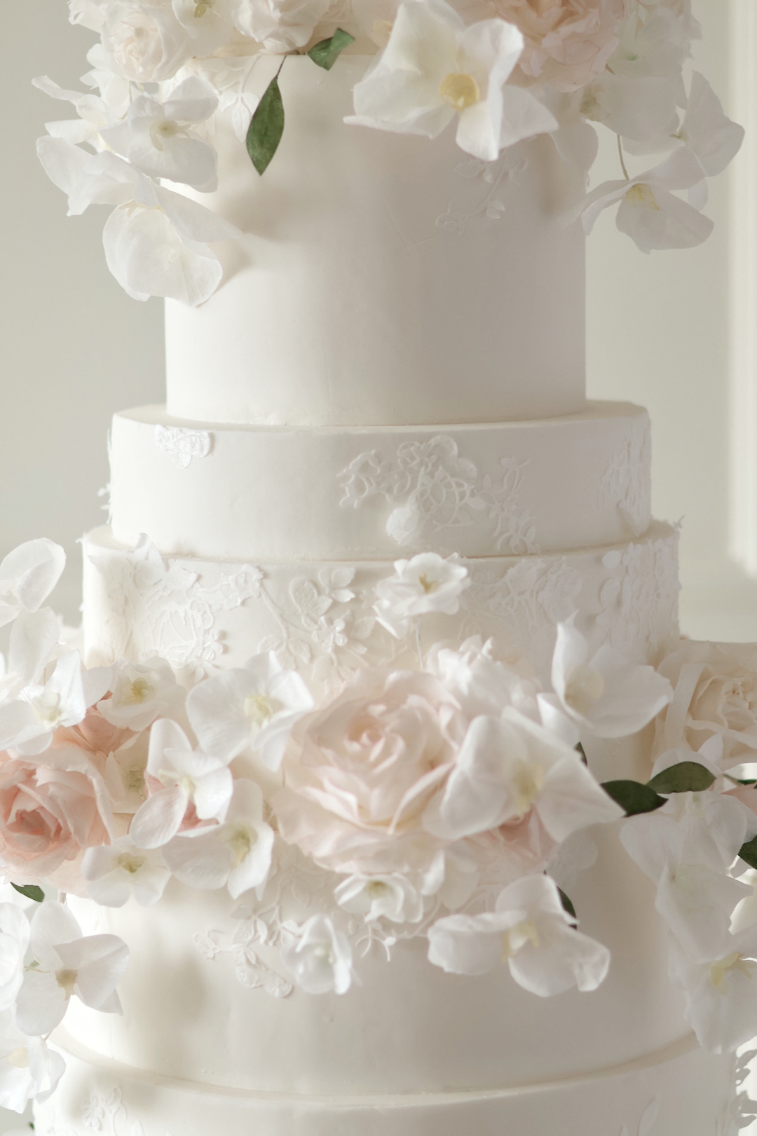 Floral wedding cake with lace appliqué