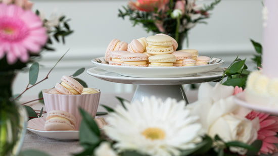 Pink macaroon on cake stand with flowers