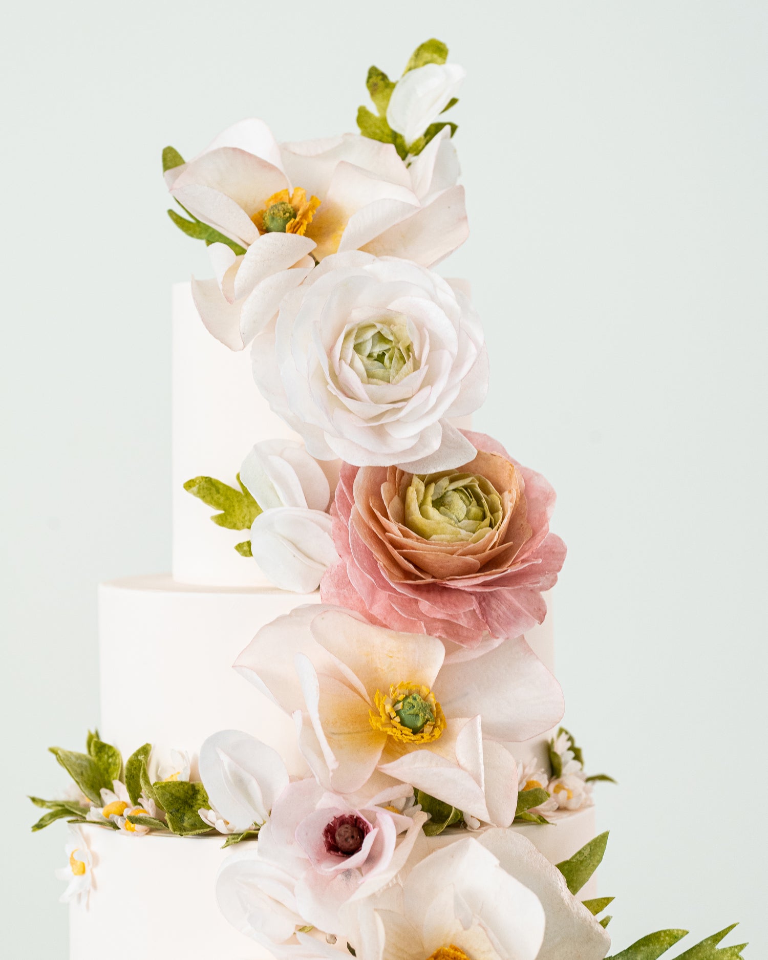 sugar nursery wedding cake garden decor peach pink greenery with ranunculus, poppies, and daisies