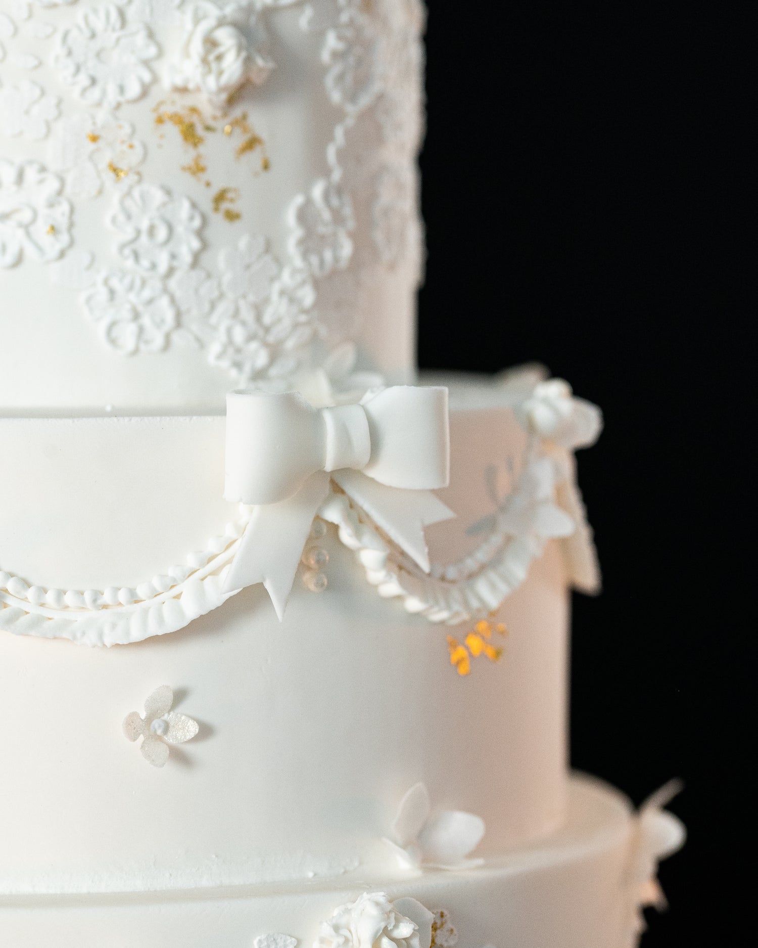 lace bow wedding cake with gold accents and royal icing piping in halifax