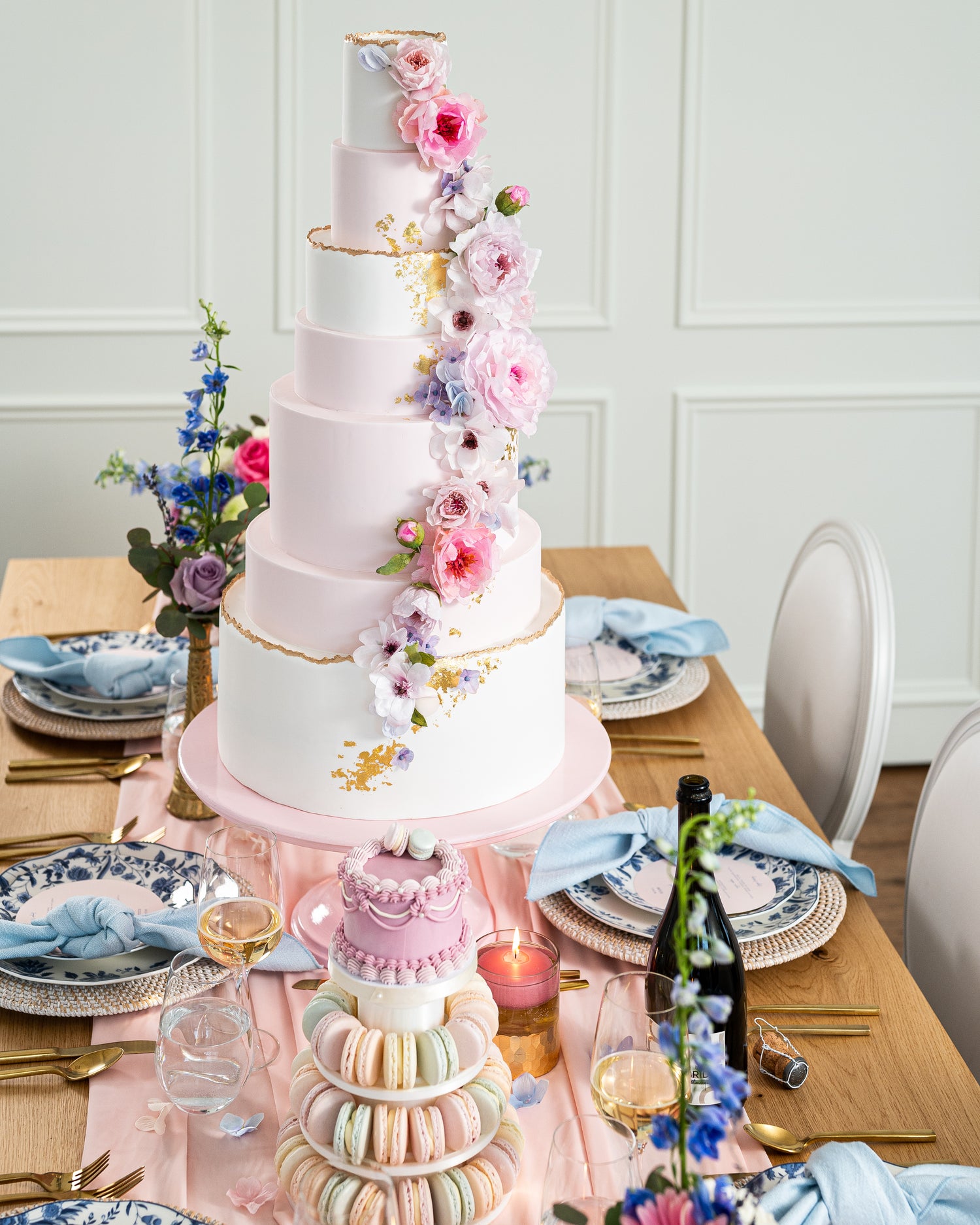 Tall wedding cake in pink lavender and gold with macarons and sweet table desserts