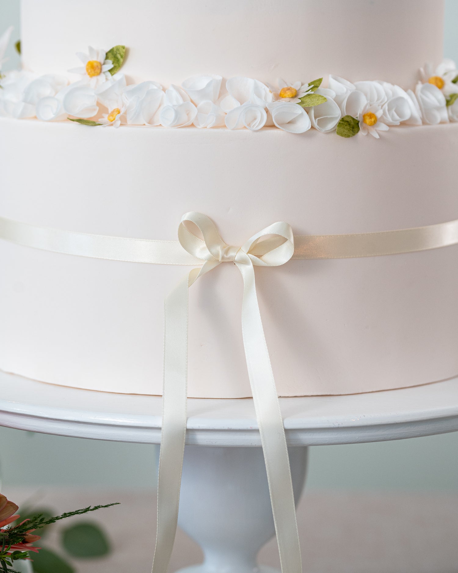pink garden flower wedding cake with ivory satin bow by sugar nursery