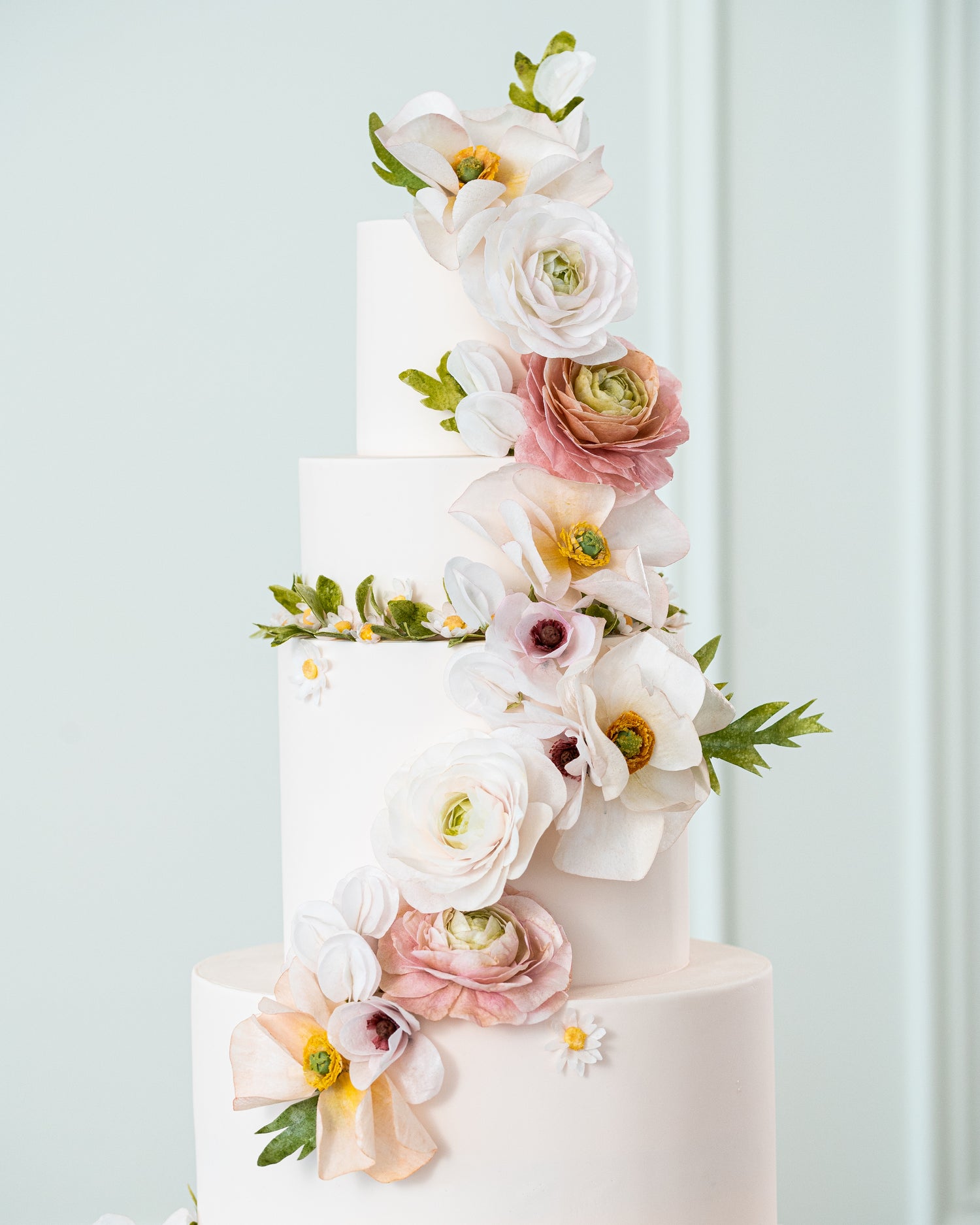 pink floral wedding cake with greenery