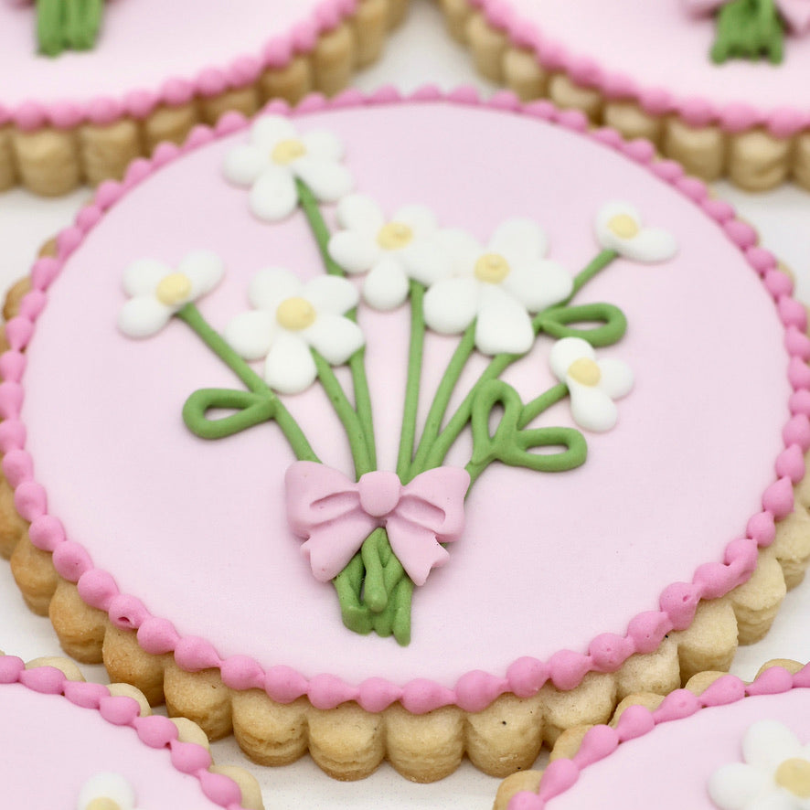 custom sugar cookies decorated with flowers and pink icing