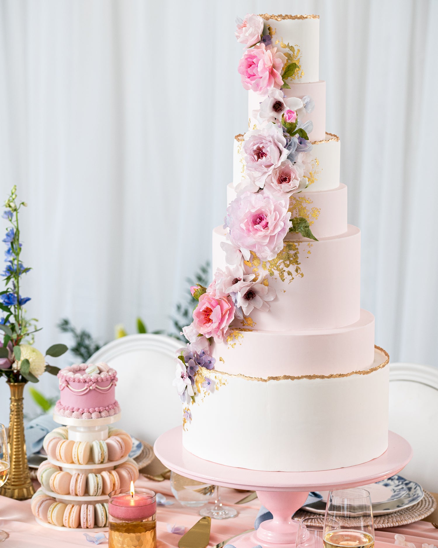 elegant flowers on tall pink and white wedding cake with macaron tower, gold leaf accents, custom wedding cake in halifax by sugar nursery cake shop